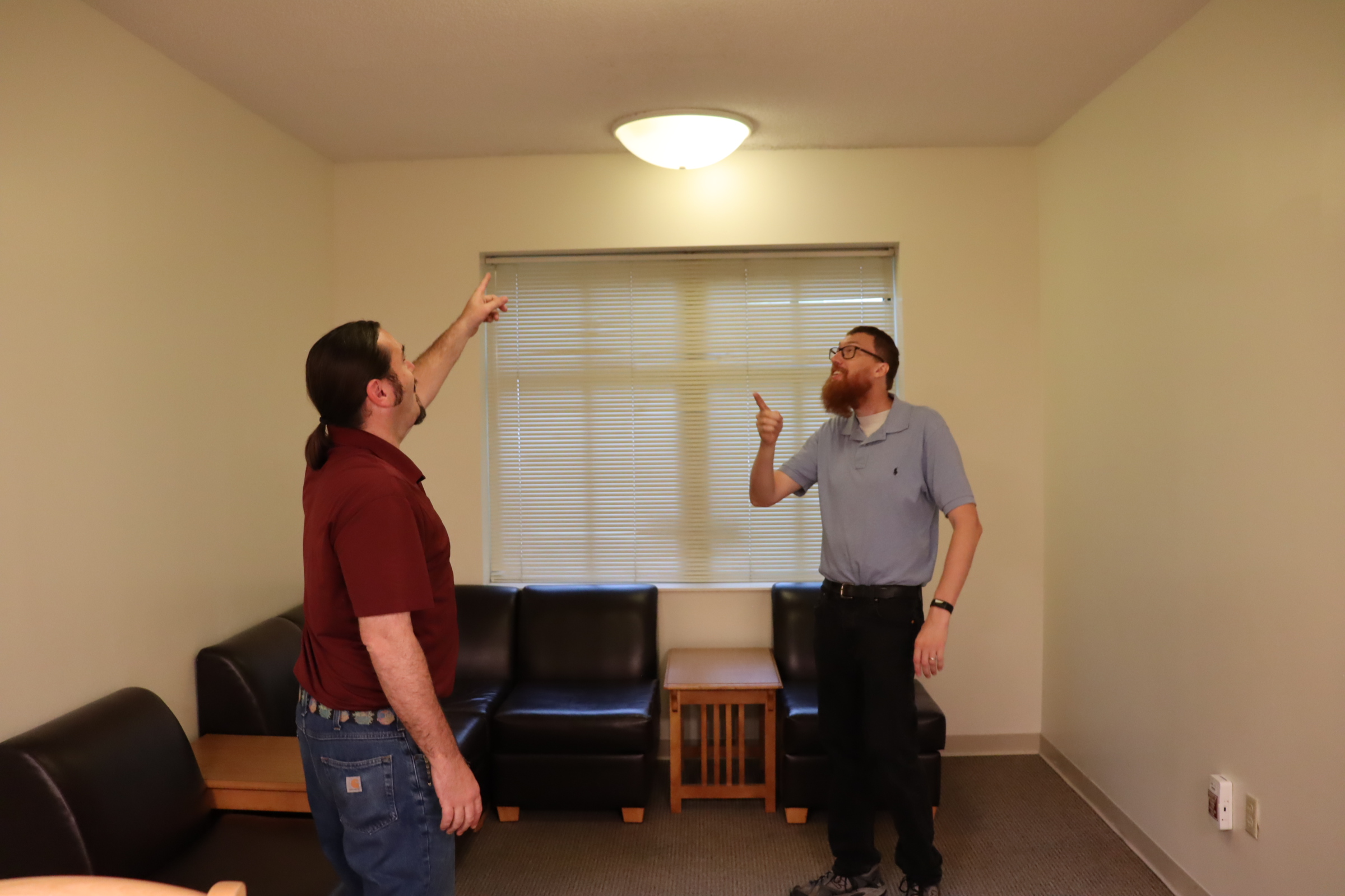 Zale Bergozza and Steve Kleuver assess lighting improvements in apartment-style residence hall, Ragans Hall